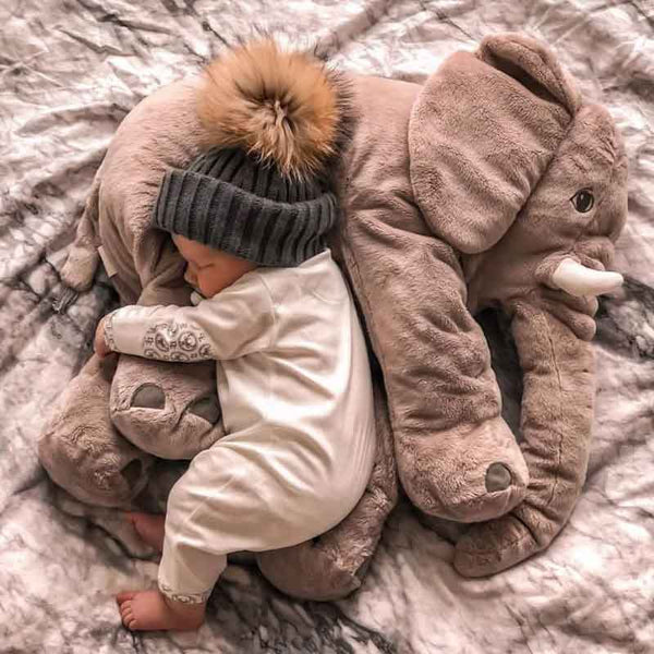 Bebe qui dort paisiblement sur l'elephant peluche bebe